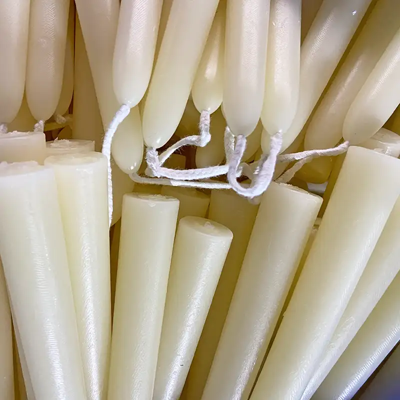 Unlabeled natural beeswax taper candles, factory finished for European importer