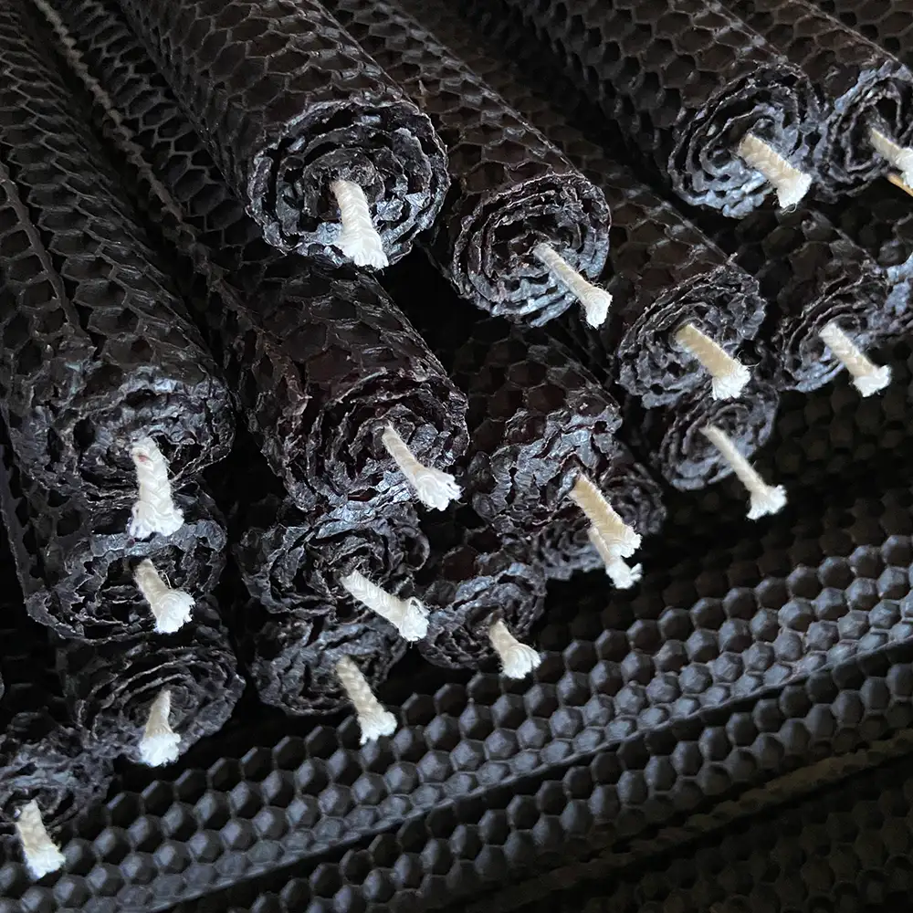 Finished hand rolled black beeswax taper candles with honeycomb texture, bulk factory shipment